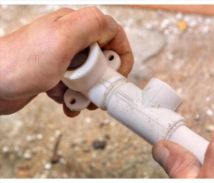 The hand of someone holding a polybutylene pipe